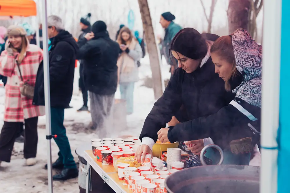 volonteri sluze hranu na trci
